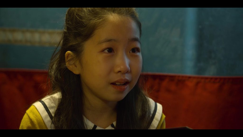 Gi-hun’s Daughter Smiles During a Sweet Conversation Gi-hun’s daughter smiling during a conversation in "Squid Game."