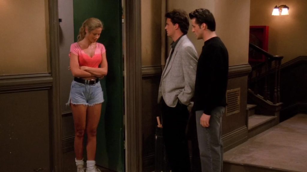 Joey and Chandler from Friends S01E19 talking to a neighbor in the hallway—a moment for cinematic English study.