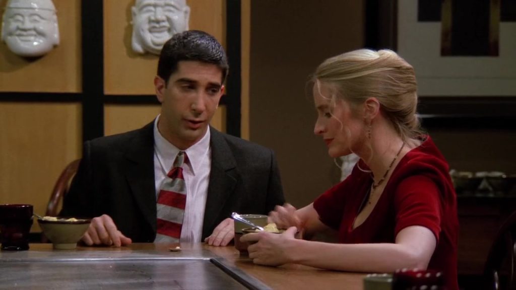 Ross sitting with his date during an awkward conversation in Friends S01 E14.