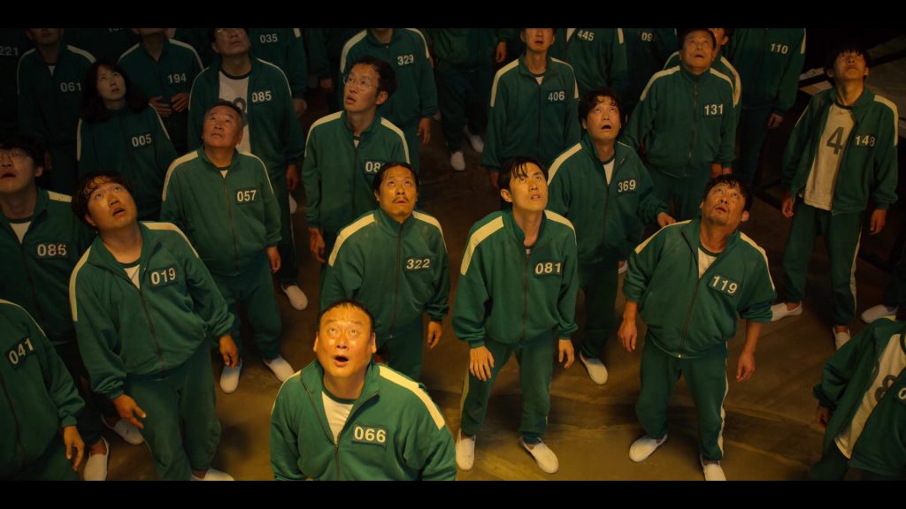 Contestants staring up at the prize money piggy bank in Squid Game Season 1 Episode 2.