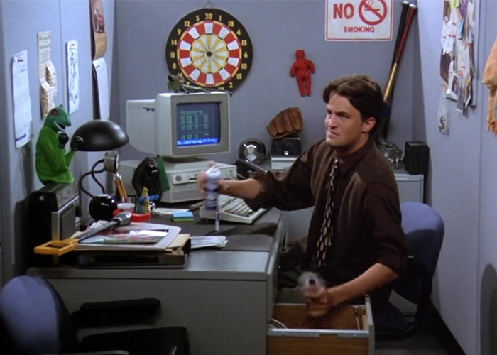 "Chandler sitting at his desk sneaking a cigarette in Friends Season 1 Episode 2."