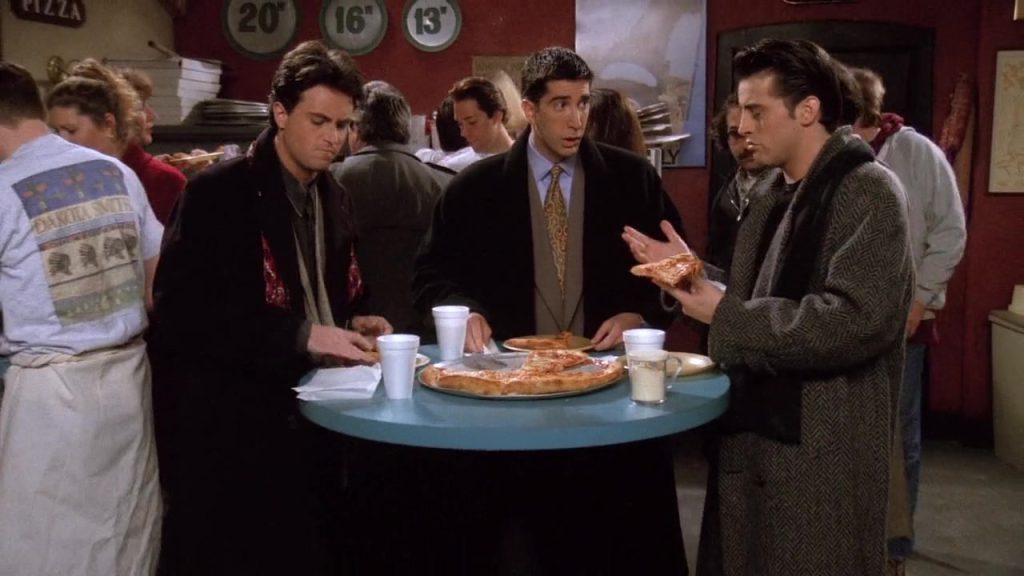 "Friends S01E19 film-based language learning scene at a pizza place with Ross, Joey, and Chandler discussing relationships."
