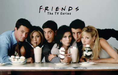 "Main cast of Friends TV series enjoying milkshakes at a diner table."