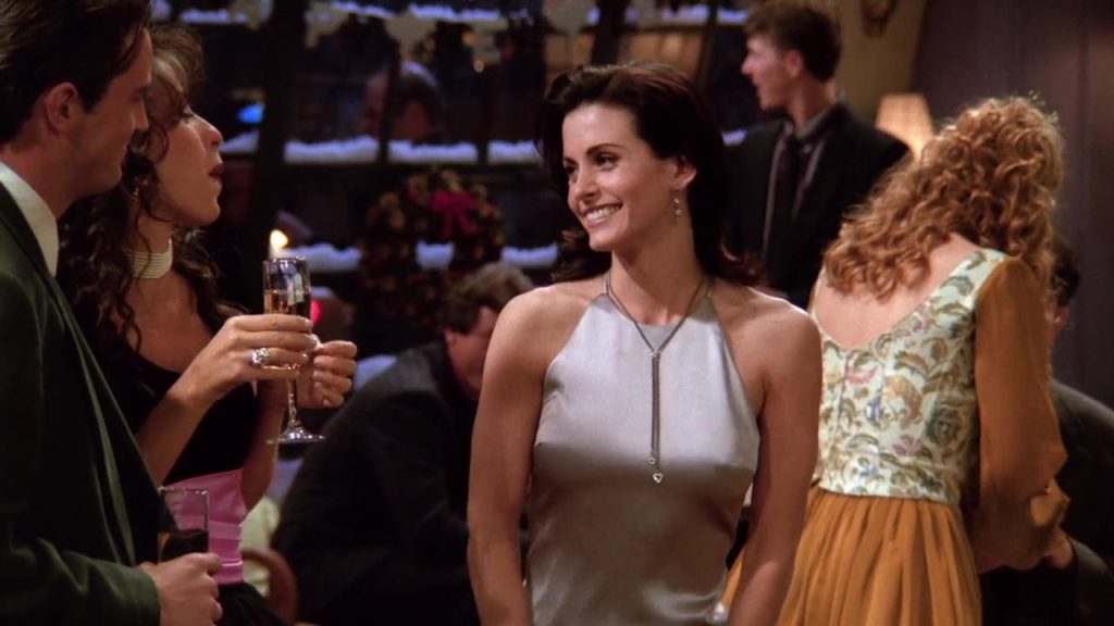 Monica Geller smiling at the New Year's Eve party in Friends S01E10