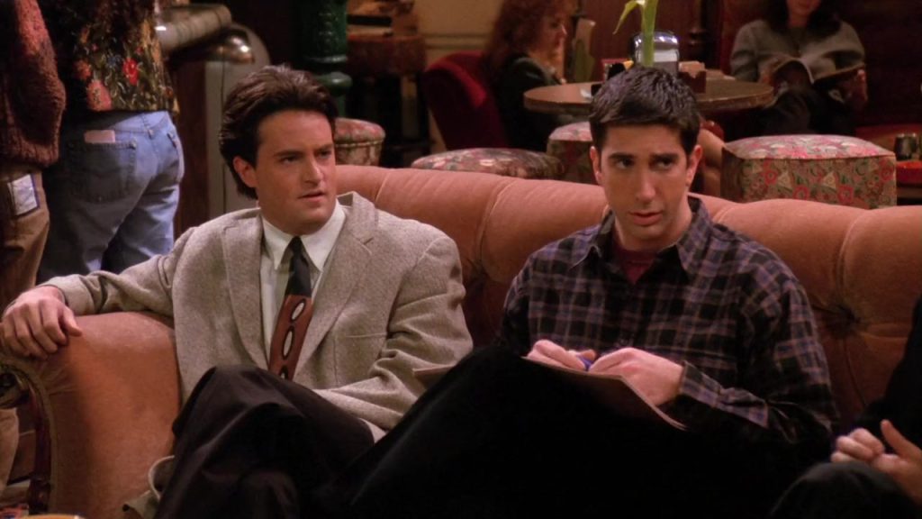 Learn English with Netflix - Chandler and Ross Conversation Chandler and Ross sitting on a couch at Central Perk in Friends S01 E13, learning English phrases.