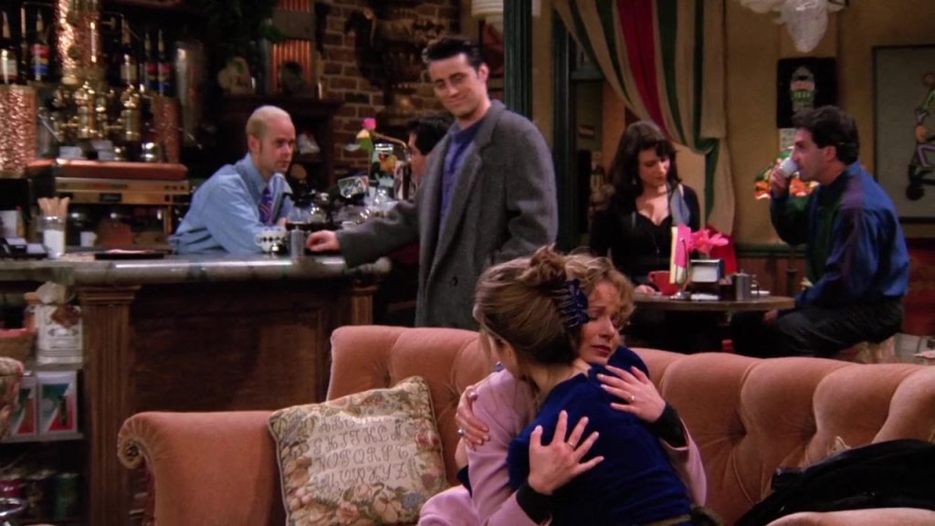 Language Learning With Netflix - Joey smiling at Central Perk, surrounded by other characters in Friends S01E20"