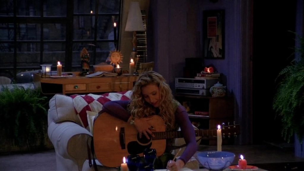 Phoebe playing guitar during a blackout in Friends S01E07.