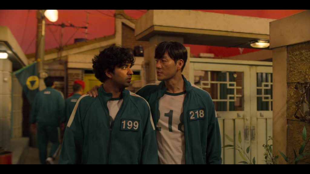 Two players in green tracksuits speaking closely, expressing concern and trust.