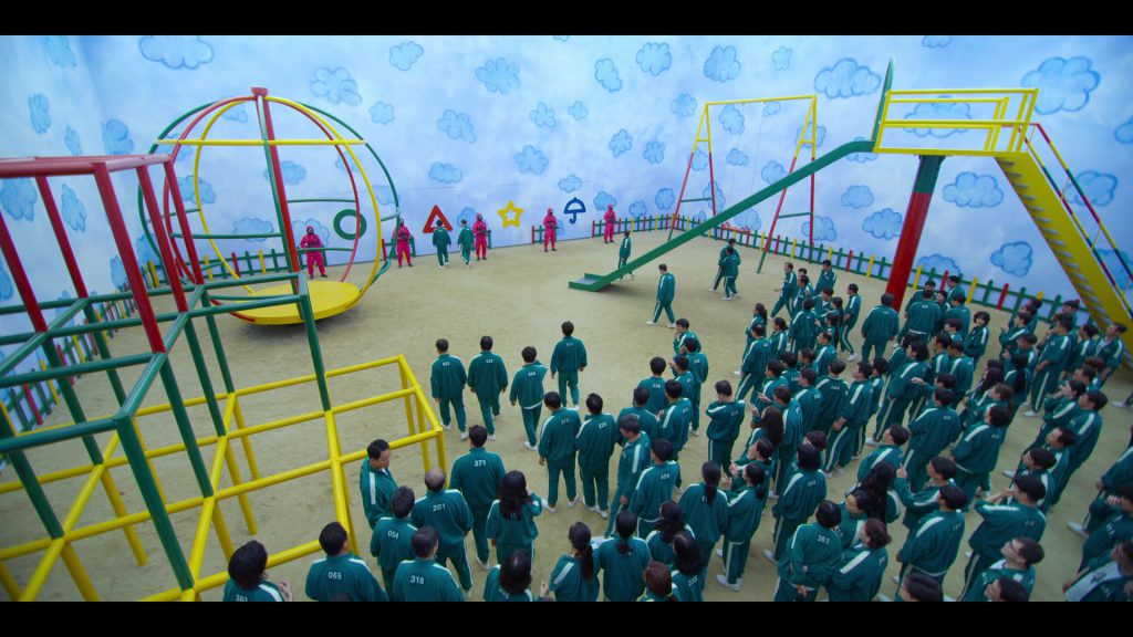 Learn English Through Movies - Playground Challenge Scene Players standing in a large playground challenge in Squad Game.