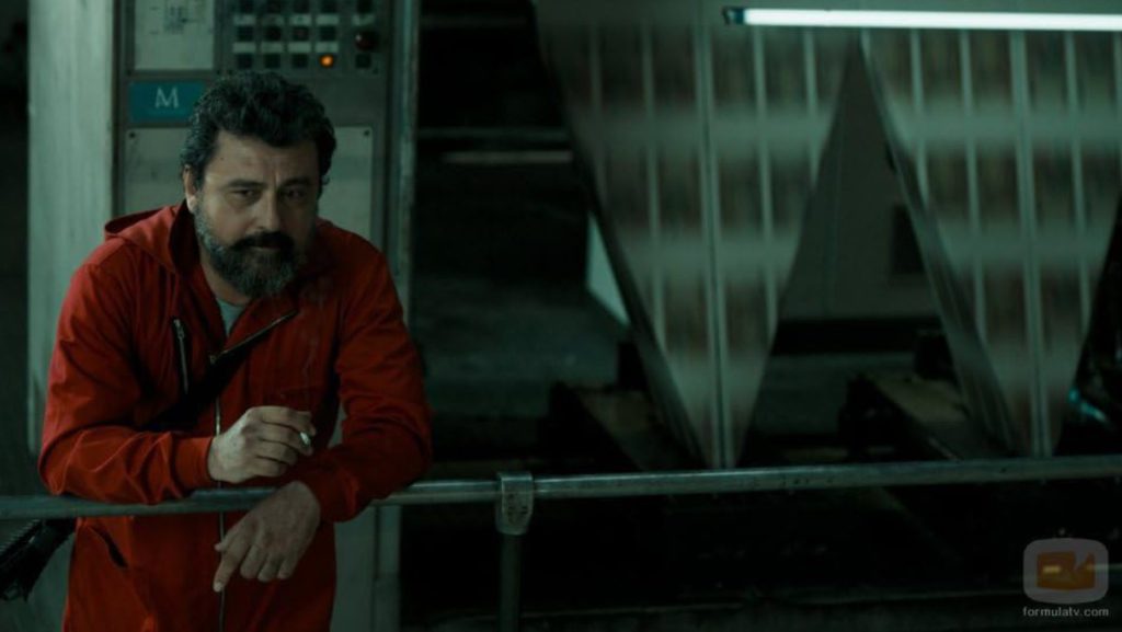 Berlin in red overalls reflecting during Monet Heist factory scene.