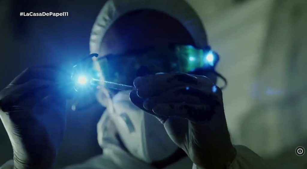 A forensic scientist examines evidence under UV light in Money Heist S01 Part 02 E11, a perfect scene for learning technical vocabulary in language learning with Netflix.