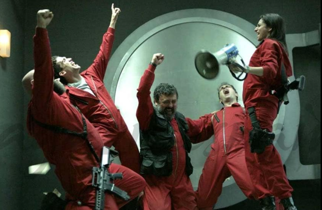 A group of Money Heist characters in red jumpsuits celebrating inside a vault, symbolizing teamwork and triumph