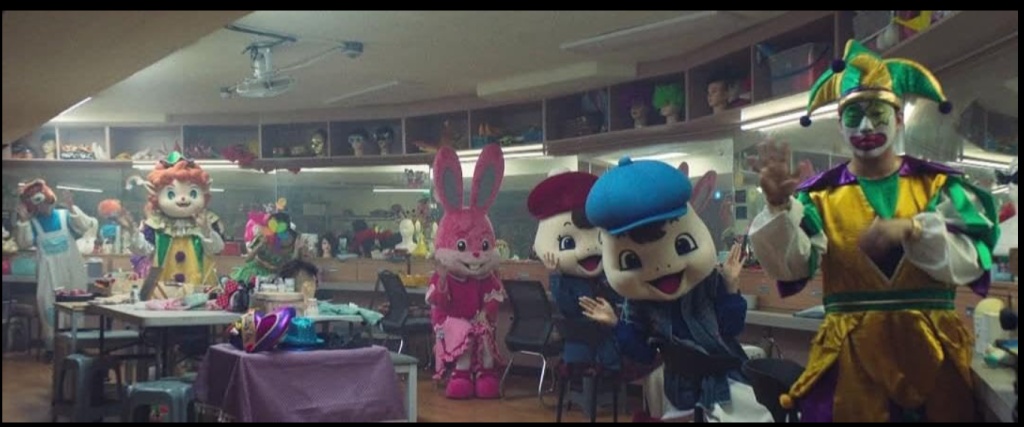 Costume Room Scene for Film Vocabulary Builder – Movie for Language room filled with colorful costumes for performers in Squid Game S02E02. Perfect scene for vocabulary building using our Film Vocabulary Builder.