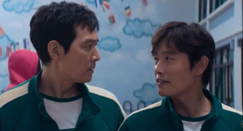 "Two main characters from Squid Game S02E05 engaged in conversation – learn English phrases through films."
