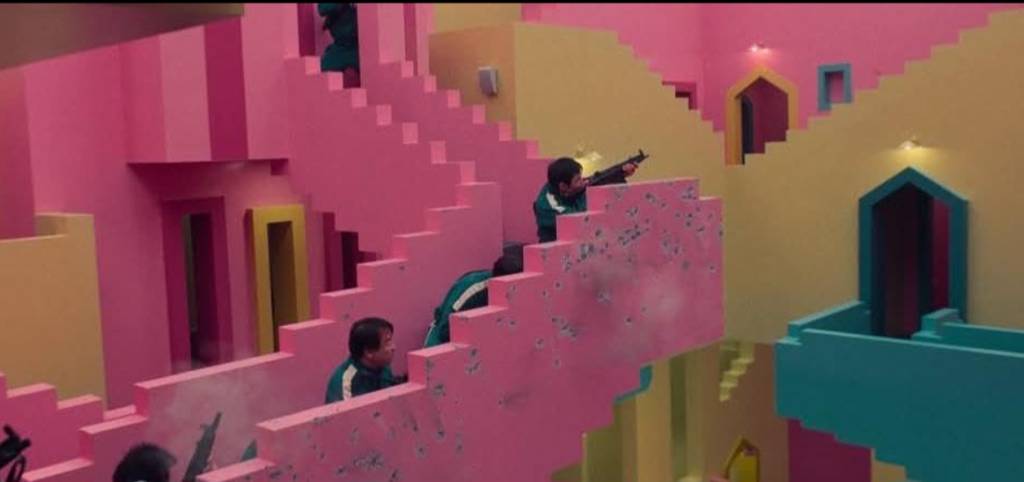 "Players shooting during an intense riot scene in Squid Game, a thrilling way to learn English vocabulary."