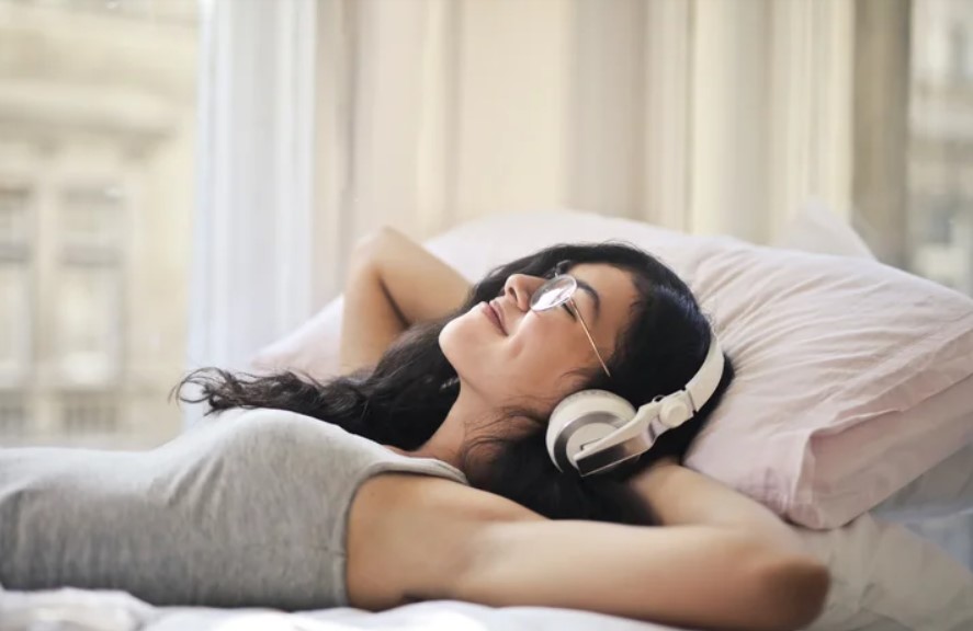 "Woman wearing headphones, enjoying podcasts for language learning with Spotify."