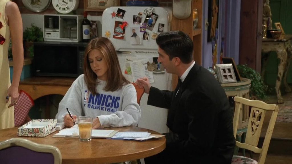 Rachel in a Knicks sweatshirt sitting with Ross in Friends S03E02, a moment showcasing cultural references for language learners.