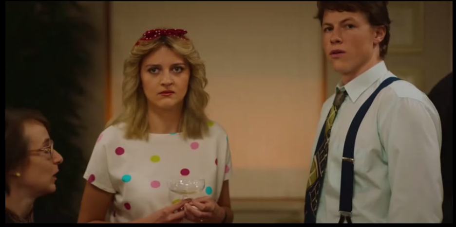 A party scene featuring a woman in a polka-dot dress and a man in suspenders, from Rival S01E02