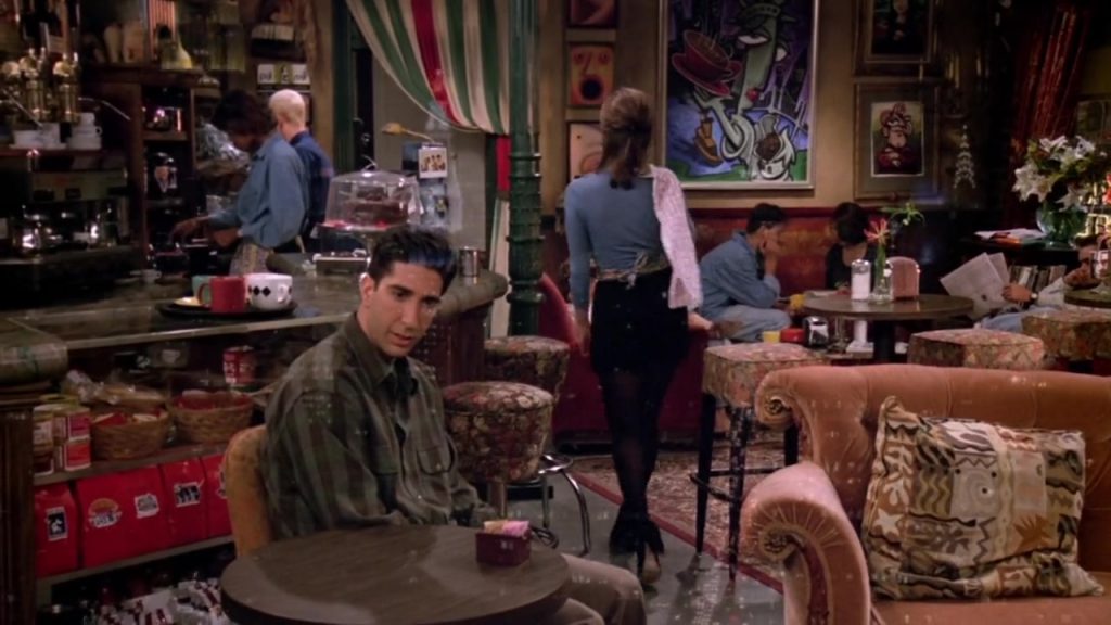 Ross sitting at Central Perk for language study movies using Friends